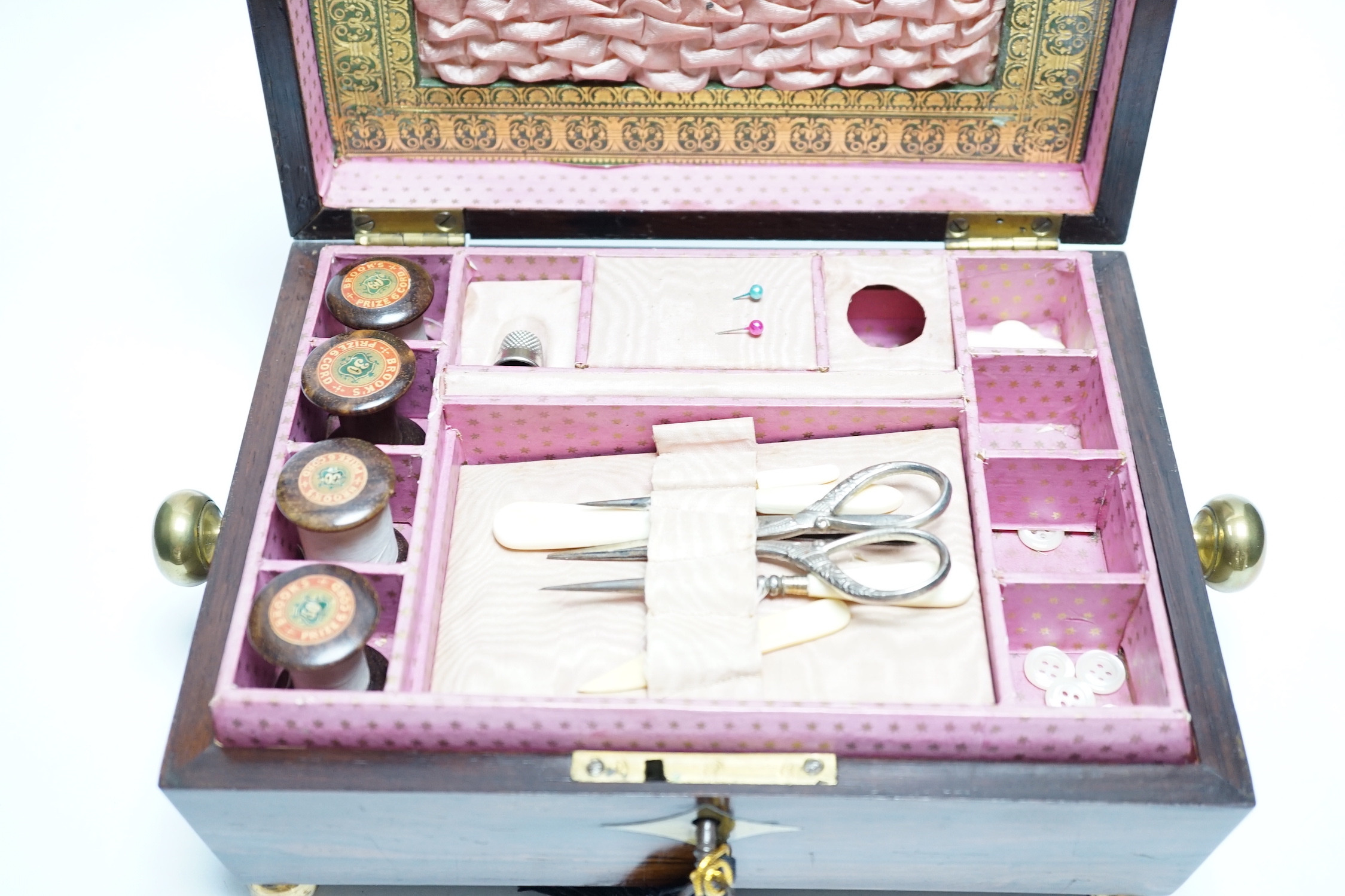 A George IV rosewood and cut brass sewing box with fitted interior, cotton reels, thread and sewing implements, 30cm wide
